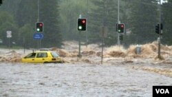 Seorang pengendara terjebak di dalam mobilnya yang terbawa arus banjir di kota Toowoomba, Queensland, Australia.