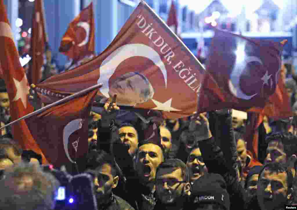 Demonstrators with banners of Turkish President Recep Tayyip Erdogan gather outside the Turkish consulate to welcome the Turkish Family Minister Fatma Betul Sayan Kaya, who decided to travel to Rotterdam by land after Turkish Foreign Minister Mevlut Cavus