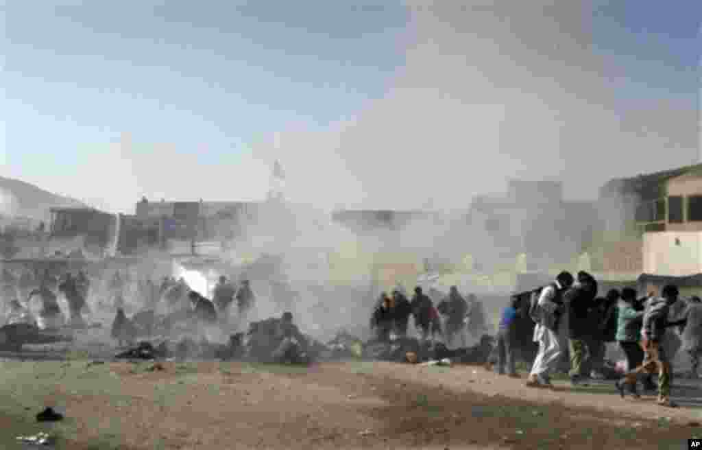 EDS NOTE: GRAPHIC CONTENT - Smoke and dust rises at the scene of a suicide attack which struck a Muharram procession in Kabul, Afghanistan, Tuesday, Dec. 6, 2011. A suicide bomber struck a crowd of Shiite worshippers marking a holy day Tuesday in the Afgh