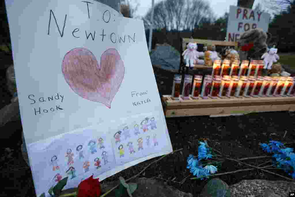 A child's message rests with a memorial for shooting victims, December 16, 2012, in Newtown, Conn.
