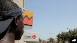 A man watches the crowd of anti-government protesters in downtown Dakar Saturday, March 19. 2011