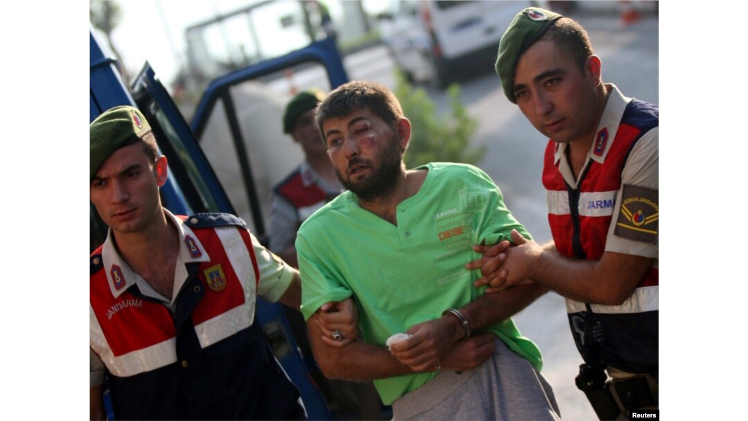 Turkish gendarmeries escort one of the 11 fugitive commandos who were involved in a bid to seize President Recep Tayyip Erdogan during a failed coup attempt last month, as he arrives at the police headquarters in Mugla, Turkey, Aug. 1, 2016.