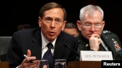 FILE - David Petraeus, former CIA director and four-star Army general, has agreed to plead guilty to mishandling classified information. He's shown at a 2012 Senate hearing with Lieutenant General Ronald Burgess in Washington, D.C. 