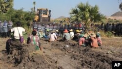 ဘော်ဒိုဇာကားရှေ့မှာ မှောက်အိပ်ပြီး တောင်းပန်နေတဲ့ ဒေသခံတောင်သူများ