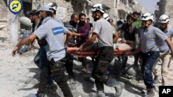 FILE - White Helmets rescuers work the site of airstrikes in the al-Sakhour neighborhood of the rebel-held part of eastern Aleppo, Syria, Sept. 21, 2016.