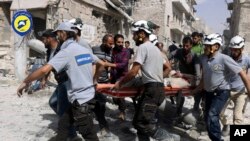 FILE - White Helmets rescue workers work the site of airstrikes in the al-Sakhour neighborhood of the rebel-held part of eastern Aleppo, Syria, Sept. 21, 2016.