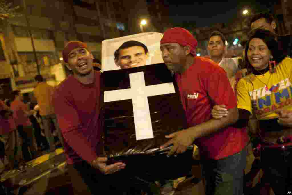 Supporters of Venezuela&#39;s President Hugo Chavez perform a mock funeral for opposition candidate Henrique Capriles as they celebrate in downtown Caracas.