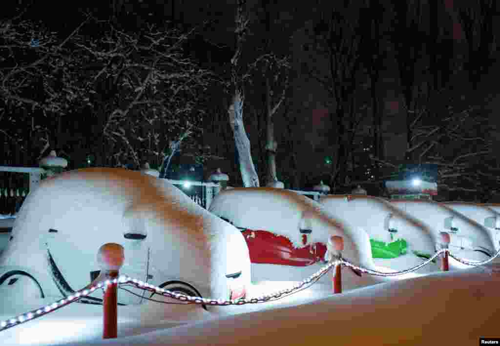 خودروهای برقی پوشیده از برف که در پارکینگ نمایشگاه ماشین در کی یف اوکراین پارک شده اند. &nbsp;