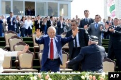 FILE - Uzbekistan's President Islam Karimov, center, dances during a state celebration of the Nowruz holiday marking the beginning of spring in Tashkent, March 21, 2015. Karimov died on Friday and his funeral is planned for Saturday.