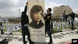 FILE - Palestinians inaugurate a square to commemorate Dalal Mughrabi, a Palestinian female militant who killed dozens of civilians in a 1978 bus hijacking in Israel, seen on a banner, in the West Bank city of Ramallah, March 13, 2011. Norway is now demanding the Palestinian Authority return a donation Oslo made to a women's center on the West Bank because the center was named after Mughrabi.
