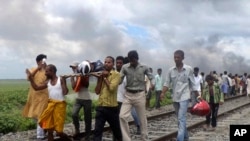 Warga desa menggotong seorang korban cidera dari stasiun Dhamara Ghat, negara bagian Bihar, India (19/8).