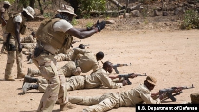 A Senagalese special forces soldier coaches a Burkinabe soldier during a marksmanship training event near Po, Burkina Faso, Feb. 23, 2019.