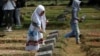 A girl places flowers on the graves of some of the victims who died during the political turmoil of 1998 during a 20th anniversary commemoration at Pondok Ranggon mass grave in Jakarta, Indonesia, May 13, 2018. 