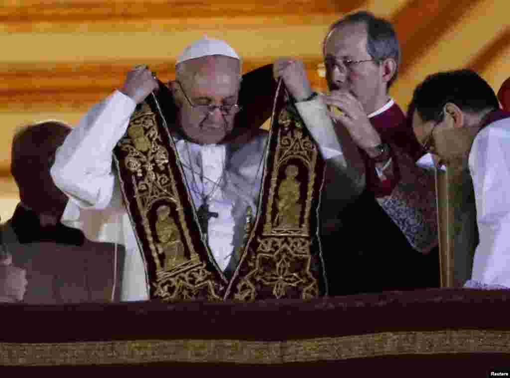 Newly elected Pope Francis (L), Cardinal Jorge Mario Bergoglio of Argentina appears on the balcony of St. Peter's Basilica after being elected by the conclave of cardinals, at the Vatican, March 13, 2013. White smoke rose from the Sistine Chapel chimney a