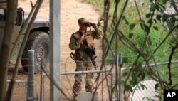 FILE - In this April 10, 2018, file frame from video, a National Guard troop watches over Rio Grande River on the border in Roma, Texas.