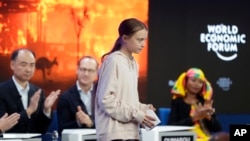 Miembros del panel aplauden a la activista del medio ambiente Greta Thunberg depués de hablar a invitados al Foro Económico Mundial de Davos, Suiza, el martes, 21 de enero de 2020.