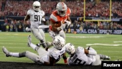 Ohio State Buckeyes running back Ezekiel Elliott (15) runs for a touchdown against Oregon Ducks defensive back Tyree Robinson (2) and defensive back Chris Seisay (12) during the third quarter in the 2015 CFP National Championship Game, Jan. 12, 2015.