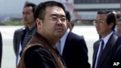 FILE - A man believed to be Kim Jong Nam, the eldest son of North Korean leader Kim Jong Il, looks at a battery of photographers as he exits a police van to board a plane to Beijing at Narita International Airport, northeast of Tokyo, May 4, 2001.