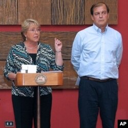 Chilean President Michelle Bachelet (L) delivers a press conference at La Moneda presidential palace in Santiago on 28 Feb 2010, next to a member of the Emergency Committee, a day after a huge 8.8-magnitude earthquake rocked the country.