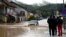 People watch a car in a flooded street in Kiseljak, Bosnia-Herzegovina, Oct. 4, 2024.