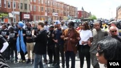 Civilians linked arms, separating police officers and restive demonstrators on a mostly peaceful afternoon in Baltimore, Maryland, April 28, 2015. (VOA photo/ Victoria Macchi)