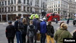 People wait to cross Regent Street, one of London's main shopping streets, a day after a new lockdown was announced during the coronavirus disease (COVID-19) outbreak in London, Nov. 1 2020. 
