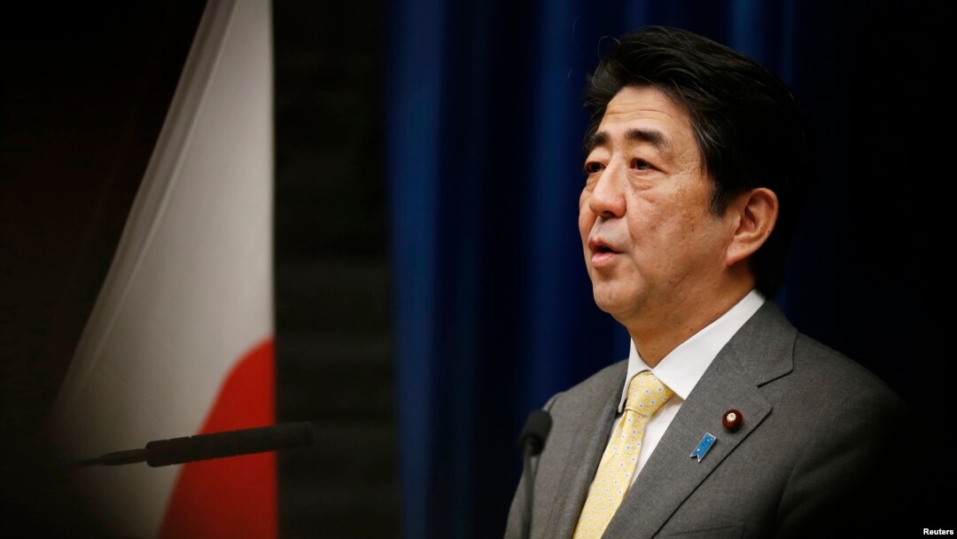 FILE - Japan's Prime Minister Shinzo Abe speaks next to the Japanese national flag.