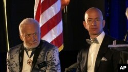 Apollo 11 astronaut Buzz Aldrin, left, and Amazon.com and Blue Origins founder Jeff Bezos attend the commemoration for the upcoming anniversary of the 1969 mission to the moon and a gala for Aldrin's nonprofit space education foundation, ShareSpaceFoundation, at the Kennedy Space Center in Cape Canaveral, Fla., July 15, 2017. 