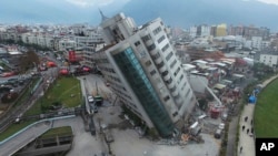 A residential building leans on a collapsed first floor following an earthquake, Wednesday, Feb. 7, 2018, in Hualien, southern Taiwan. Rescue crews continue to try free people from damaged buildings after a strong earthquake hit near Taiwan's east coast and killed at least four people. (Central News Agency via AP)