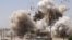 In this undated photo posted on a militant website that frequently carries official statements from the Islamic State extremist group, smoke and debris go up in the air as Shiite's Al-Qubba Husseiniya mosque explodes in Mosul. 