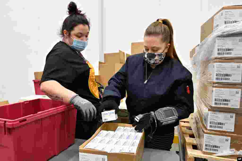 Employees with the McKesson Corporation scan a box of the Johnson &amp; Johnson COVID-19 vaccine while filling an order at their shipping facility in Shepherdsville, Kentucky. 