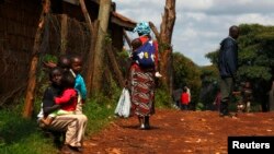 Seorang ibu menggendong anaknya di punggungnya di wilayah kumuh Kangemi, Nairobi, Kenya, 23 April 2013 (Foto: dok).