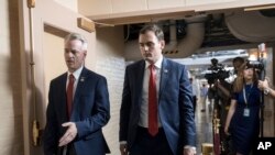 Rep. Steve Russell, R-Okla. (L), and Rep. Mike Gallagher, R-Wis., walk to a closed-door meeting with House Republicans seeking more information about compromise legislation on immigration, at the Capitol in Washington, June 21, 2018.