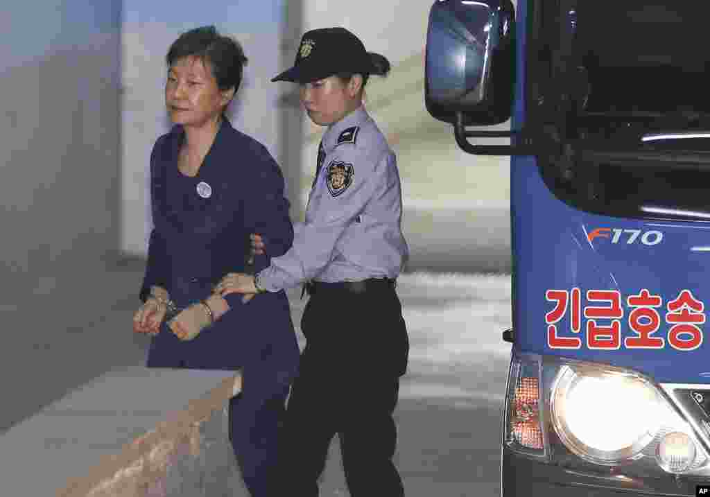 Former South Korean President Park Geun-hye, left, arrives for her trial at the Seoul Central District Court in Seoul. Lawyers for jailed Park have resigned in an apparent protest against a court decision to extend her detention.
