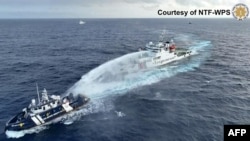 This handout taken and released on December 4, 2024 by the National Task Force for the West Philippine Sea (NTF-WPS) shows a China coast guard ship, right, deploying a water cannon at a Philippine Bureau of Fisheries and Aquatic Resources vessel.