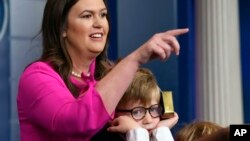 White House press secretary Sarah Sanders, standing next to her son Huck Sanders, calls on a child during a briefing at the White House in Washington, April 25, 2019. Children of journalists and White House staff were invited to attend the briefing and ask Sanders questions.