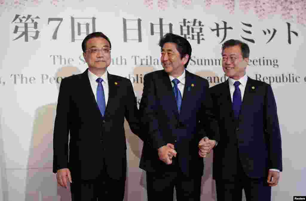 2018年5月9日中国总理李克强（左）在东京与安倍首相（中）和韩国总统文在寅在举行三方会谈之前携手亮相。