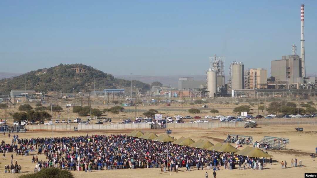 Mineworkers queue for check-ins near Lonmin's Marikana platinum mine before returning to work, June 25, 2014.