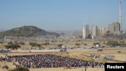 Mineworkers queue for check-ins near Lonmin's Marikana platinum mine before returning to work, June 25, 2014.