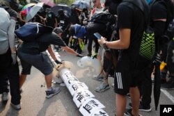 Demonstrators put papers on a fallen smart lamppost during a protest in Hong Kong, Aug. 24, 2019.