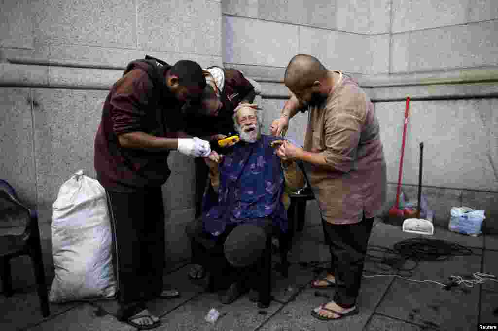 Members of the Franciscan fraternity &quot;O Caminho&quot; (The Way) shave and cut the nails of a homeless man in front of Se Cathedral in downtown Sao Paulo, Brazil, July 21, 2015. Sao Paulo, South America&#39;s largest city, has an estimated 16,000 homeless people according to the Town Hall.