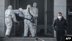 Medical staff transport a patient to Jinyintan Hospital, where patients infected by a mysterious SARS-like virus are being treated, in Wuhan, in China's central Hubei province, Jan. 18, 2020.