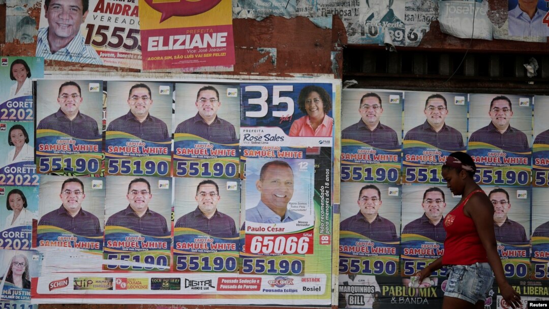 A woman walks past election posters during municipal elections in Sao Luis, Brazil, Oct. 2, 2016. 