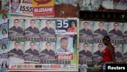 A woman walks past election posters during municipal elections in Sao Luis, Brazil, Oct. 2, 2016. 