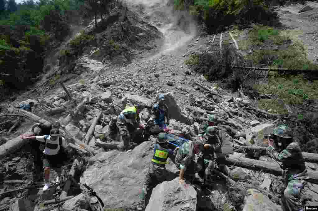 中国武警在四川阿坝州九寨沟县附近发生强烈地震后抢救幸存者（2017年8月9日）。美国地质调查局测量的震级为6.5级，中国地震中心说，震级为7级。整个地区毁损房屋10万多间，电力中断。这次地震距2008年重创该地区的八级地震所在地很近，八万七千多人在那次地震中死亡或者失踪。与此同时，当局正在应对新疆的强震，美国地质调查局测量的震级为6.3级。新华社说，至少三名村民在住房倒塌时受伤。