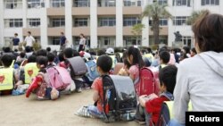 Para pelajar berkumpul di halaman SD Ikeda di Prefektur Osaka setelah dievakuasi dari gedung sekolah menyusul gempa bumi di Osaka, bagian barat Jepang, Senin, 18 Juni 2018. (Foto: Kyodo via Reuters)