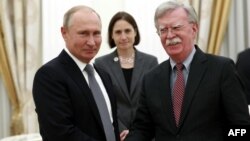 El presidente ruso Vladimir Putin le da la mano a al Asesor de Seguridad Nacional de EE.UU., John Bolton, durante una reunión en el Kremlin en Moscú el 23 de octubre de 2018.