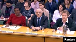 Oxfam's chief executive Mark Goldring, center, Oxfam's international director Winnie Byanyima (left) and Oxfam's chair Caroline Thomson attend a hearing of the British parliament's International Development Committee in London, Britain, Feb. 20, 2018. (REUTERS/Parliament TV handout)