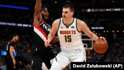 Nikola Jokić u prodoru pored Morisa Harklesa u prvom poluvremenu pete utakmice polufinala Zapada u "Pepsi centru" u Denveru (Foto: AP/David Zalubowski)