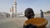 FILE - A young talibe raises a begging bowl in front of the grand mosque in Touba, in the central region of Senegal, Feb. 23, 2012. 